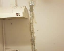 Zepsute gniazdko w kuchni, wymagające naprawy przez elektryka.