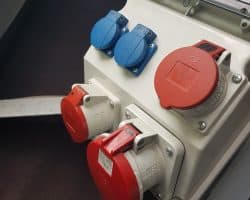 Łódź ze skrzynką elektryczną zawierającą czerwony, niebieski i biały sprzęt elektryczny.
